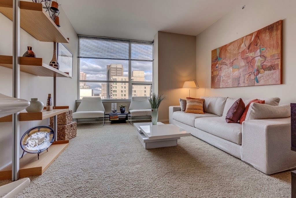 A living room with a large window overlooking a cityscape.