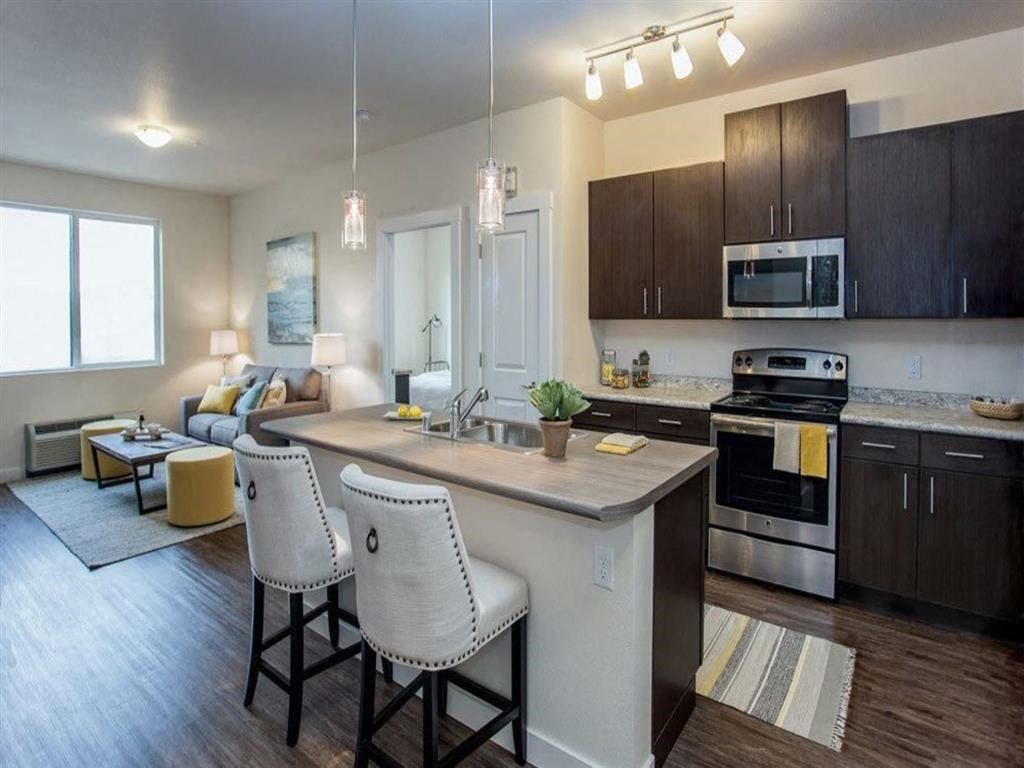 a kitchen and living room with an island and chairs