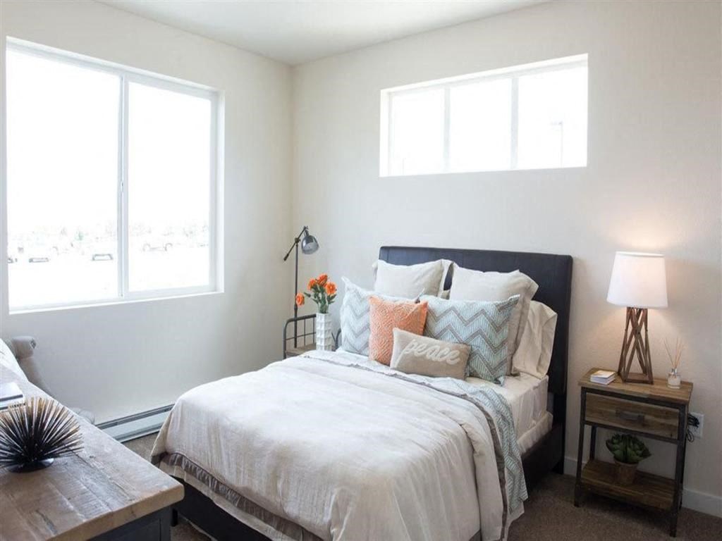 a bedroom with a bed and two windows