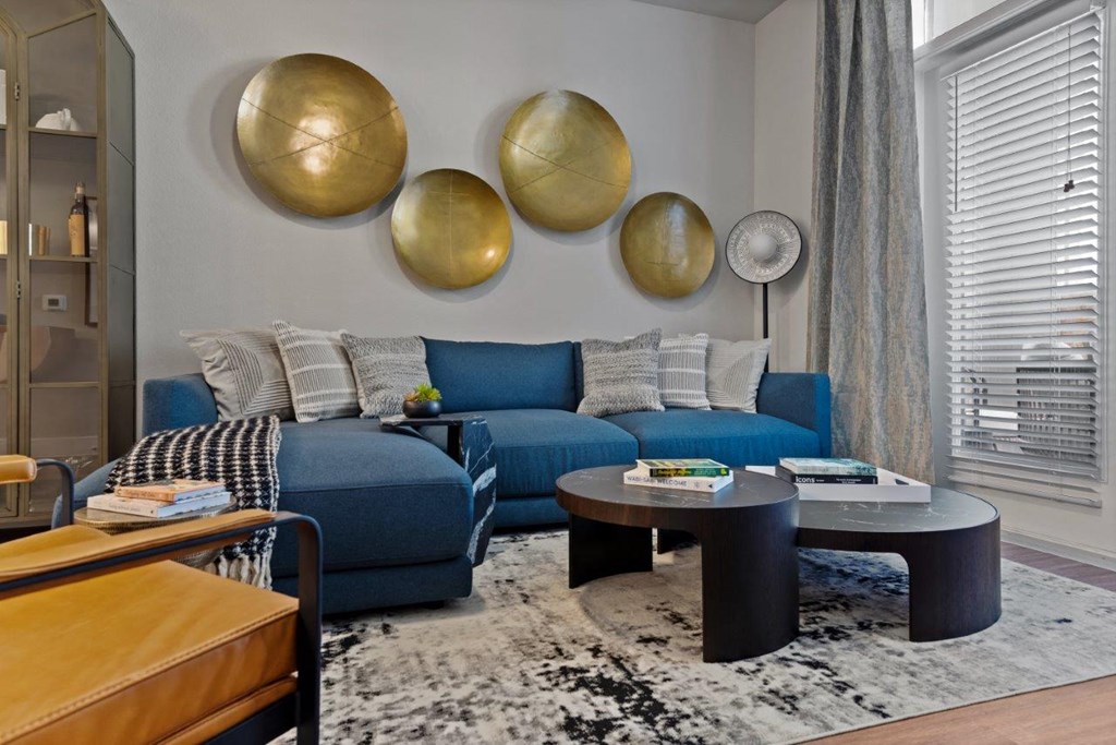 a living room with a blue couch and tables