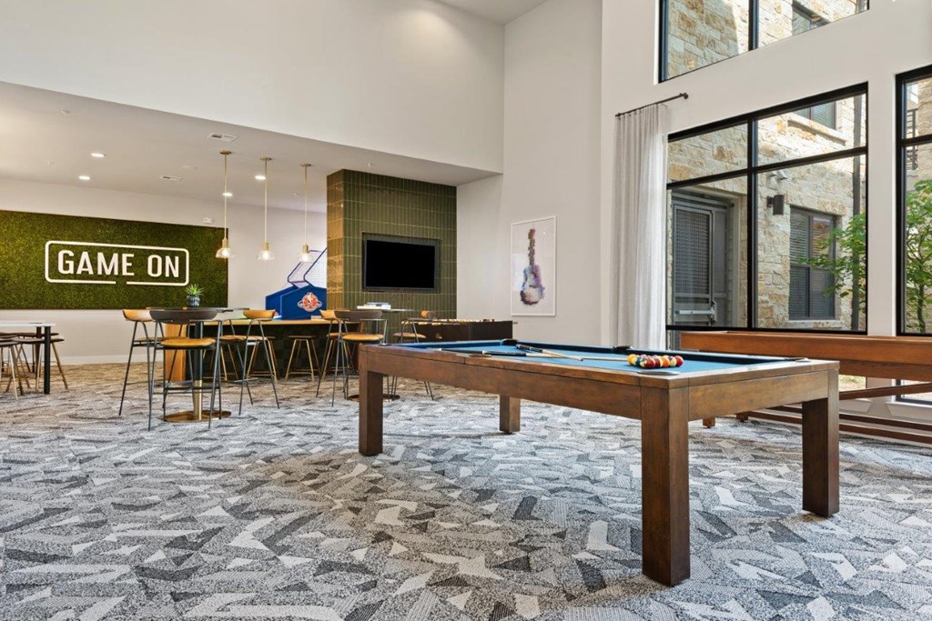 a game room with a pool table and a bar