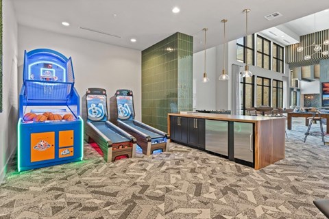 the lobby or reception area of a hotel with game machines and benches