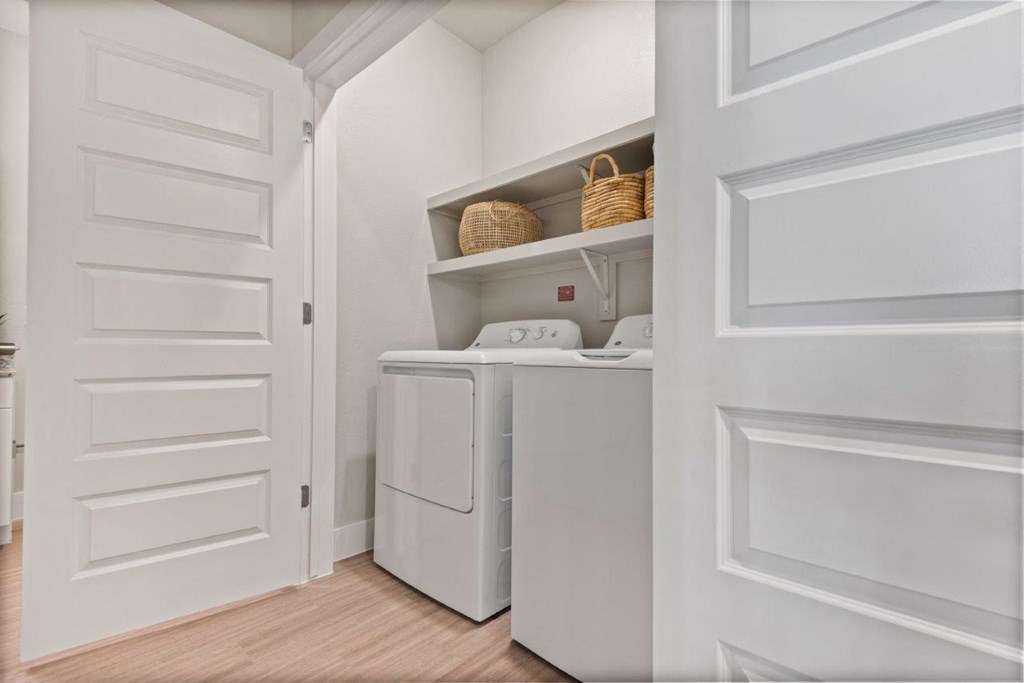a laundry room with a washer and dryer and a white door