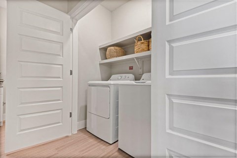 a laundry room with a washer and dryer and a white door