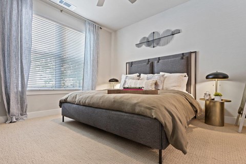 a bedroom with a bed and a large window