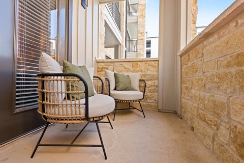 a porch with two chairs and a window