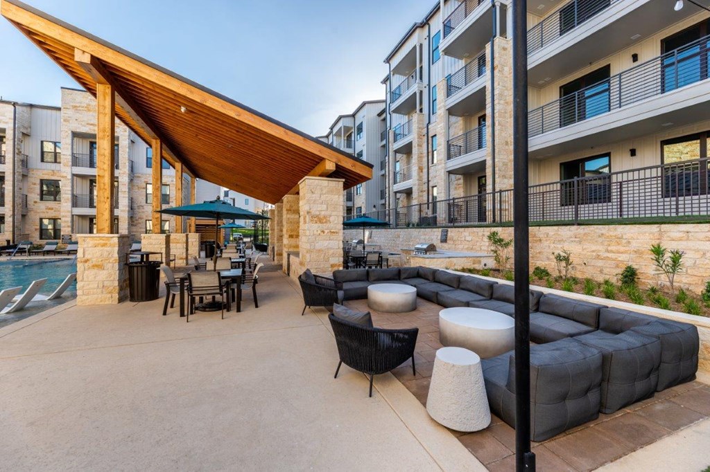 a patio with couches tables and chairs and a pool