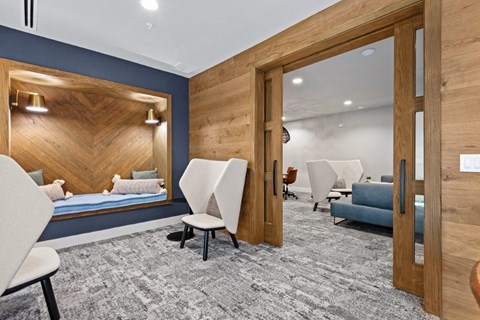 a patient room with a bed and chairs and a mirror