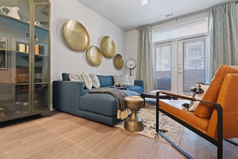 a living room with a couch and a table in front of a window