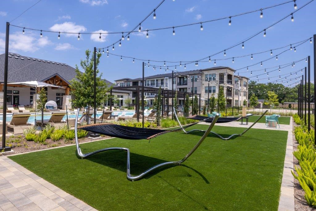 a lounge area with hammocks and lights at the preserve at great pond apartments in windsor