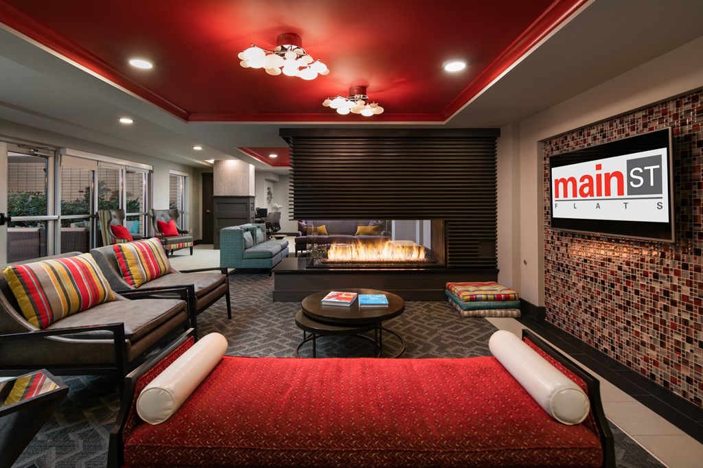 A living room with a red couch and a fireplace.