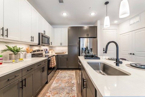 A kitchen with a white counter top and a sink.