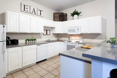 a kitchen with white cabinets and a counter top