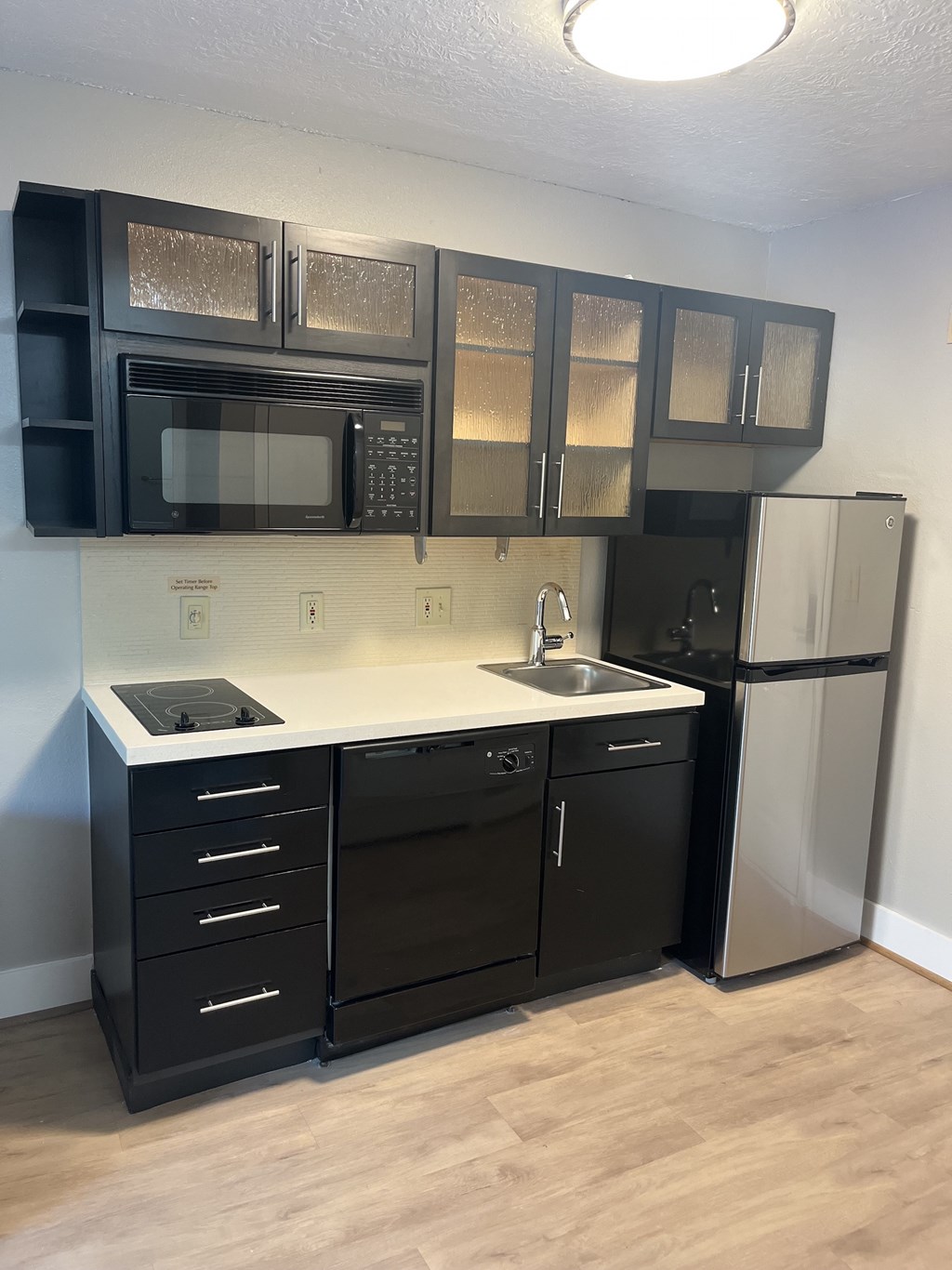 A kitchen with black cabinets and a white countertop.
