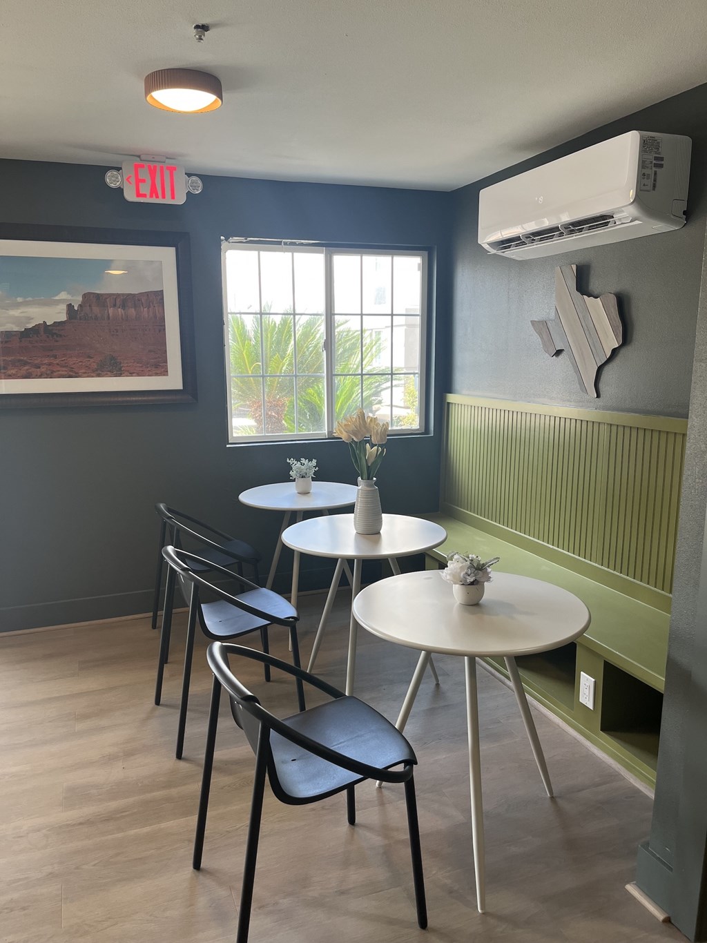 A restaurant with a green wall and a white table.