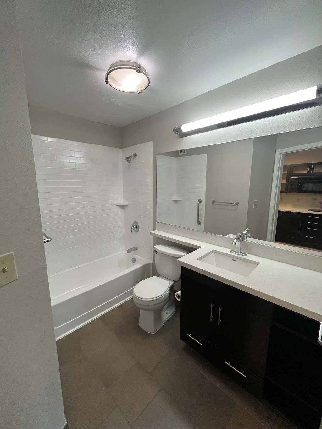 A bathroom with a toilet, sink, and mirror.
