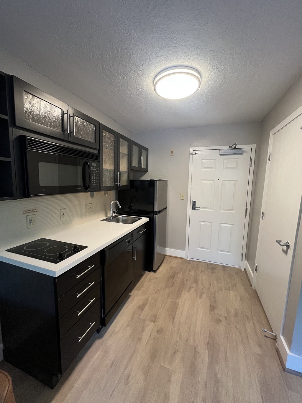 A kitchen with black cabinets and a white countertop.