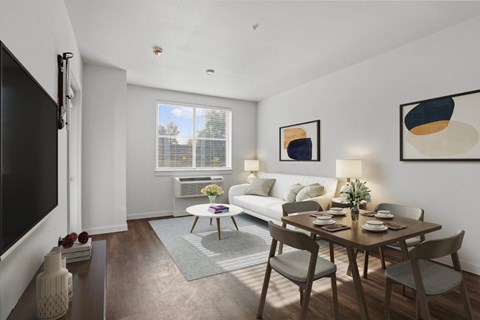 A modern living room with a wooden dining table and chairs.