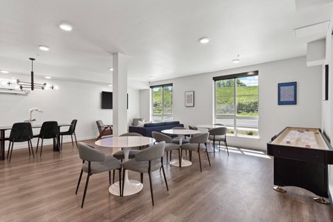 A room with a pool table and a dining table with chairs.