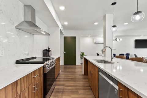 A modern kitchen with wooden cabinets and a marble countertop.