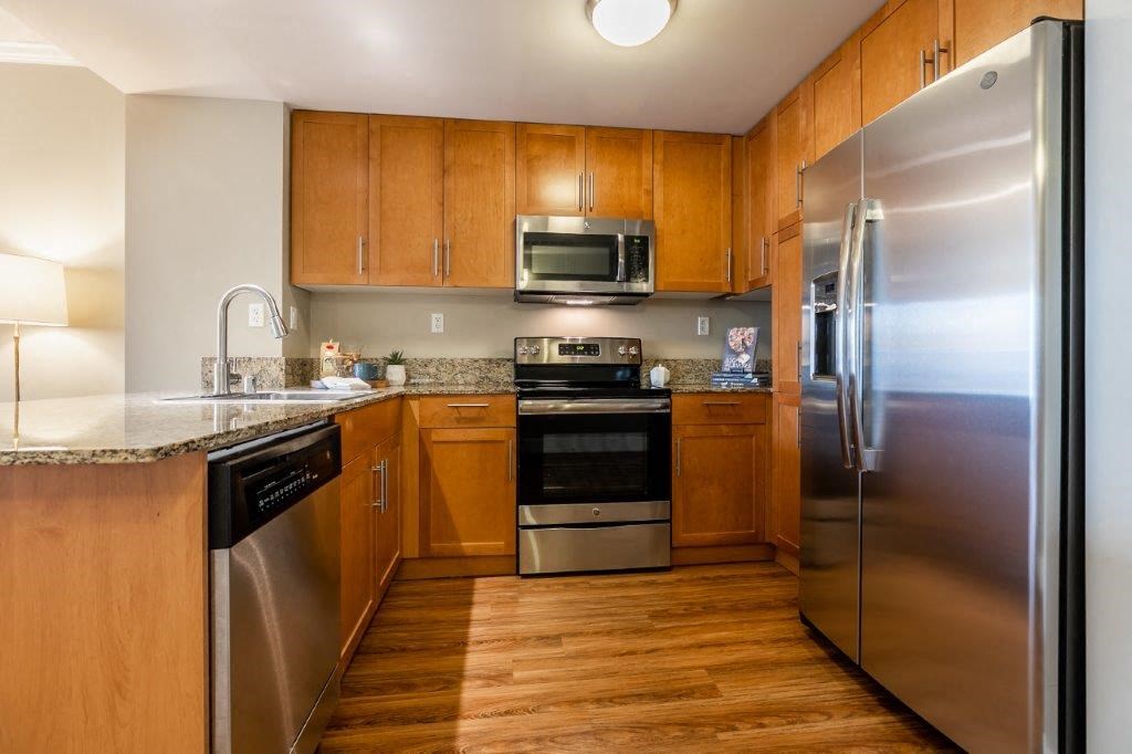 The Mercer kitchen area with fridge, sink, and appliances