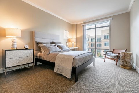 a bedroom with a bed and a large window