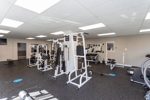 A gym with a variety of equipment including a leg press machine.