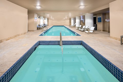 a swimming pool in the middle of a room with chairs and a pool
