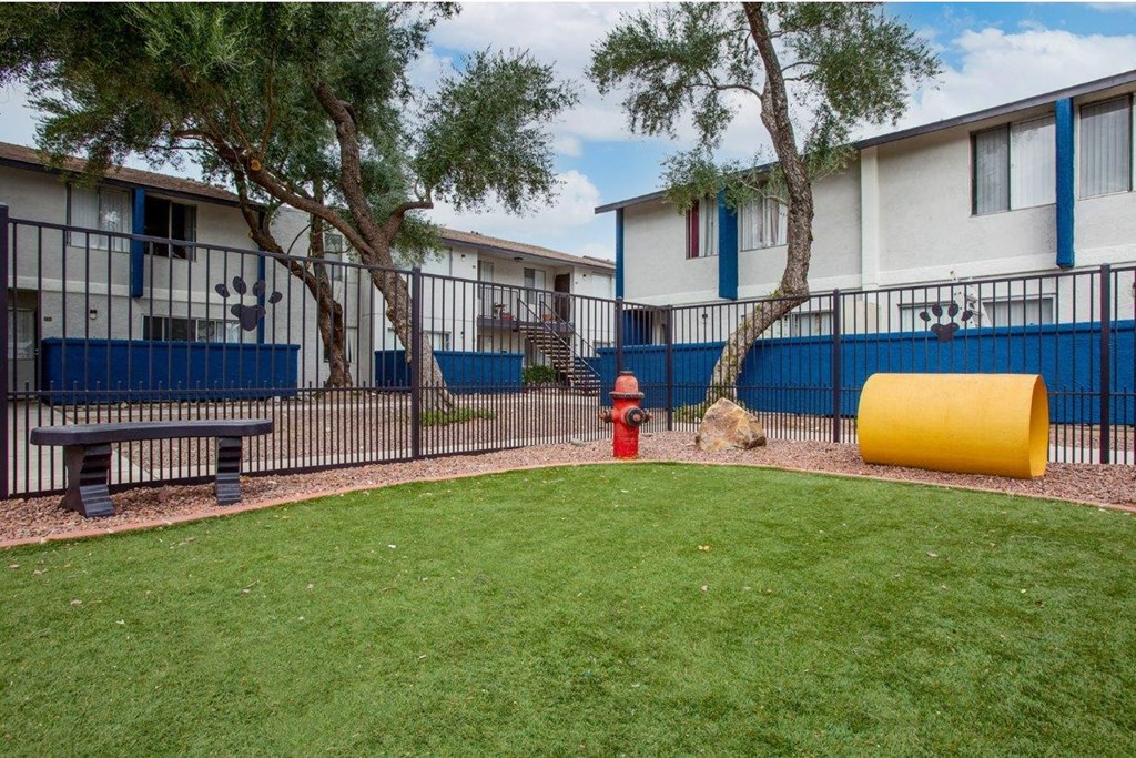 a red fire hydrant in the middle of a yard in front of some apartments