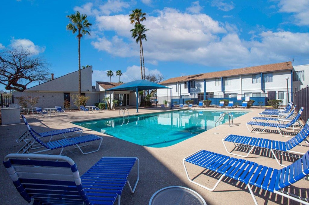 a resort style pool with blue chairs and chairs around it