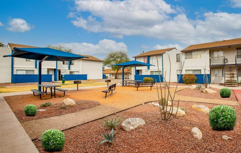 a courtyard with picnic tables and umbrellas