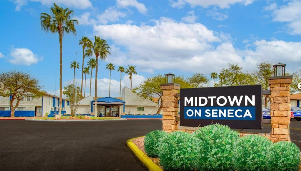 a sign for midtown on seneca in front of a building with palm trees