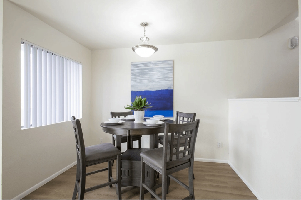 a dining room with a table and chairs and a window