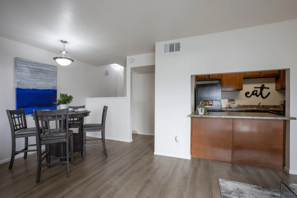 a dining room and kitchen area with a table and chairs