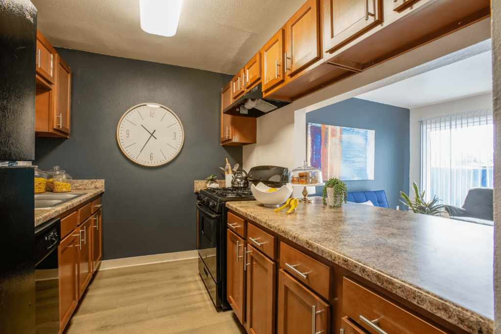 full kitchen with granite countertops and stainless steel appliances and a large clock