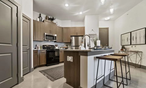 A modern kitchen with a white countertop and wooden cabinets.