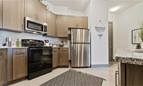 A kitchen with wooden cabinets and a black oven.