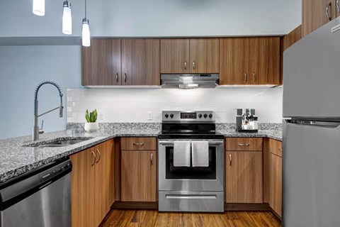 A modern kitchen with wooden cabinets and stainless steel appliances.