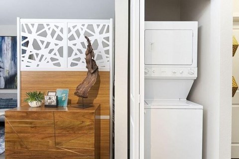 A white oven is in a kitchen next to a wooden dresser.