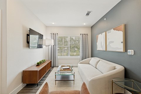 A modern living room with a white sofa and a wooden bench.