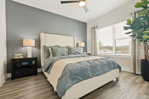 A bedroom with a large bed and a ceiling fan.