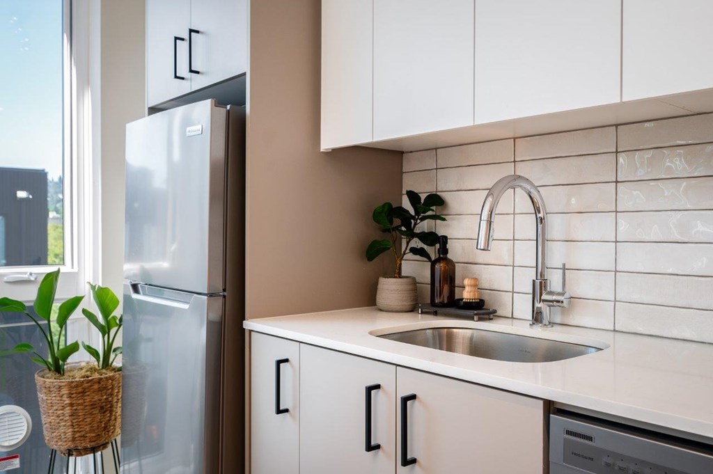 MERX Slabtown kitchen with a white fridge, sink, and cabinets.