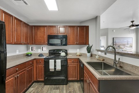 A kitchen with wooden cabinets and black appliances.