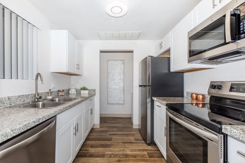 A kitchen with white cabinets and stainless steel appliances.