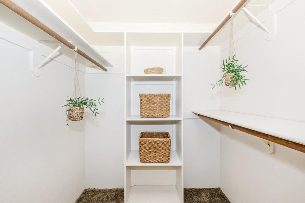 A white shelf with a basket and a plant on it.