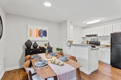 A modern kitchen with a dining table set for two.