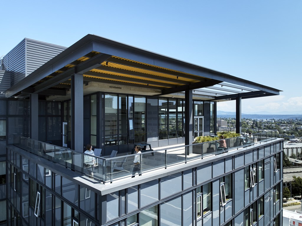 a view of the rooftop terrace of a building with people sitting on it