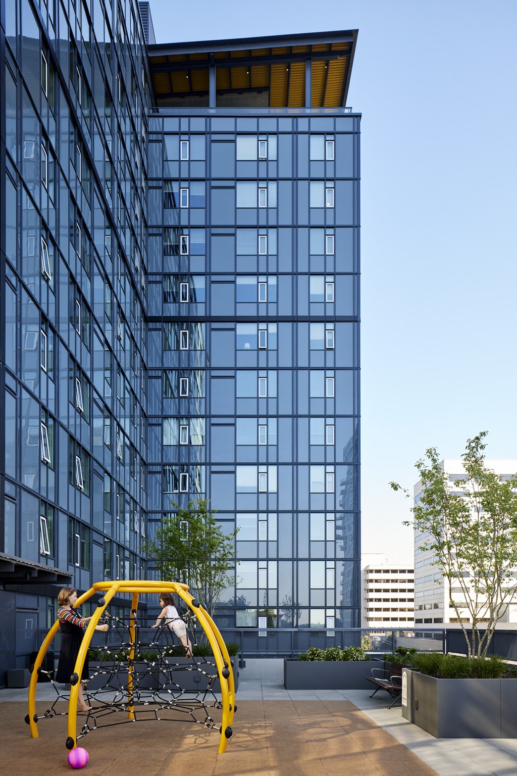 people playing on a playground in front of a tall building