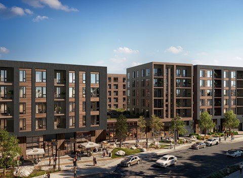 A modern apartment complex with cars parked in front.