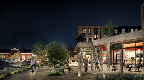 A nighttime scene of a city street with people walking and a bicyclist.